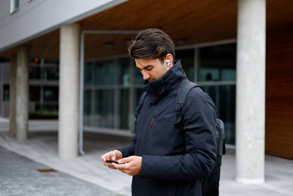 Mann med telefon utendørs