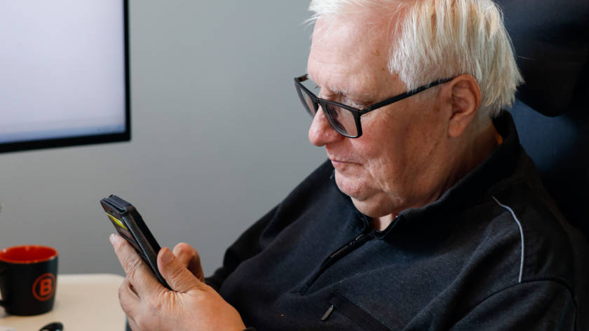Eldre mann ser på telefonen